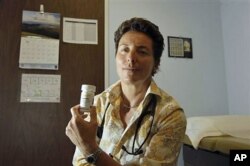 Dr. Lisa Sterman ຍົກແກ້ວຢາ Truvada ອັນນຶ່ງຂຶ້ນມາ ຊຶ່ງທ່ານ ນາງໄດ້ເອົາໃຫ້ຄົນປ່ວຍຂອງທ່ານນາງຫລາຍສິບຄົນທີ່ມີຄວາສ່ຽງສູງ ຕໍ່ການຕິດເຊື້ອໄວຣັສ HIV ທີ່ San Francisco ໃນເດືອນ ພຶດສະພາ, 2012.