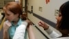 FILE - A woman is given a flu shot on the Emory University campus in Atlanta. 