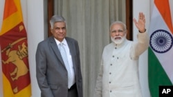 Indian Prime Minister Narendra Modi, right, waves to the media next to his Sri Lankan counterpart Ranil Wickremesinghe before their meeting in New Delhi, India, April 26, 2017. 