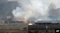 Humo saliendo de edificios en un campo militar en Adén, Yemen, tras una explosión en un arsenal.
