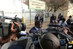 Zimbabwean President Emmerson Mnangagwa's legal representative Paul Mangwana talks to the media outside the Constitutional Court in Harare, Aug. 22, 2018.