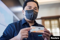 Menteri Badan Usaha Milik Negara Erick Thohir memegang kotak vaksin COVID-19. (Foto: Reuters)