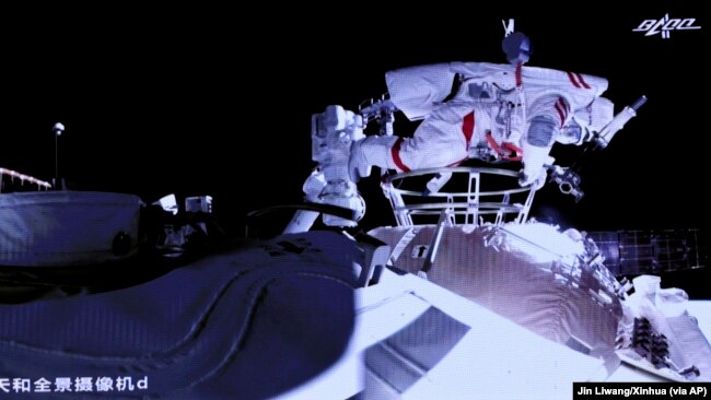 Foto yang dirilis oleh Kantor Berita Xinhua ini menunjukkan layar di Pusat Kontrol Luar Angkasa Beijing yang menampilkan astronaut Liu Boming keluar dari modul inti stasiun ruang angkasa baru China di luar angkasa pada Minggu, 4 Juli 2021. (Foto: Xinhua via AP/Jin Liwang)