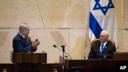 El primer ministro de Israel, Benjamin Netanyahu, (izquierda) aplaude al vicepresidente de EE.UU., Mike Pence, en el Parlamento en Jerusalén, el lunes, 22 de enero de 2018. 