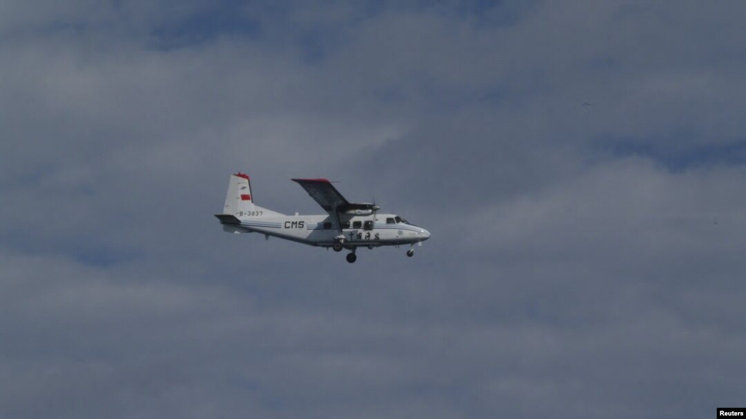 An airplane belonging to China's state oceanic administration flies past about 15 km (9 miles) south of one of the disputed islets in this handout released by 11th Regional Coast Guard Headquarters-Japan Coast Guard, December 13, 2012.