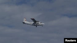 日本海岸警卫队2012年12月13日发布的新闻通报的图片显示属于中国海洋局的一架飞机飞过一个具有争议的小岛以南大约15公里远的空域
