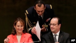 Francois Hollande, right, President of France, is handed papers prior to the signing ceremony for the Paris Agreement on climate change, April 22, 2016 at U.N. headquarters.