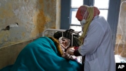 FILE - An elderly Kashmiri tuberculosis patient receives treatment at the Chest Disease Hospital on World Tuberculosis Day in Srinagar, India, March 24, 2015.
