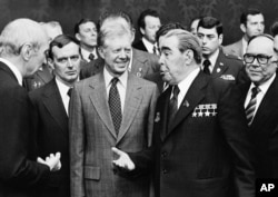 FILE - American President Jimmy Carter, left, and Soviet General Secretary Leonid Brezhnev meet for the first time, in Vienna, June 15, 1979.