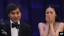 Actress JJ Jia, right, and producer Gordon Lam celebrates after winning the Best Film award for the movie 'Gallants' at the Hong Kong Film Awards in Hong Kong, Sunday, April 17, 2011.