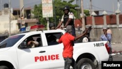 Un manifestant lève la main alors qu'il passe devant des policiers lors d'une manifestation pour exiger la démission du président haïtien Jovenel Moise, dans les rues de Port-au-Prince, Haïti le 11 octobre 2019. REUTERS / Andres Martinez Casares - 