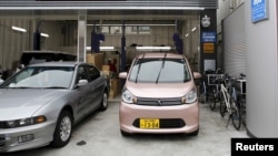 FILE - А Mitsubishi Motors Corp's mini-car eK Wagon (R) is seen parked at the service dock of a dealership in Tokyo, Japan, Apr. 21, 2016.