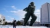 A woman walks past a the Runner, sculptured by Kostas Varotsos, after a snowstorm, in Athens, on Tuesday, Jan. 25, 2022. 