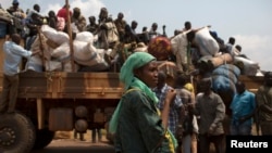 FILE - A woman looks on as people on a truck gather their belongings during a road repatriation to Chad in the capital Bangui, January 22, 2014. 