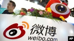 Staff members wait for visitors at a booth for Chinese microblogging website Sina Weibo at the Global Mobile Internet Conference in Beijing, April 27, 2017. The event features current and future trends in the mobile Internet industry.