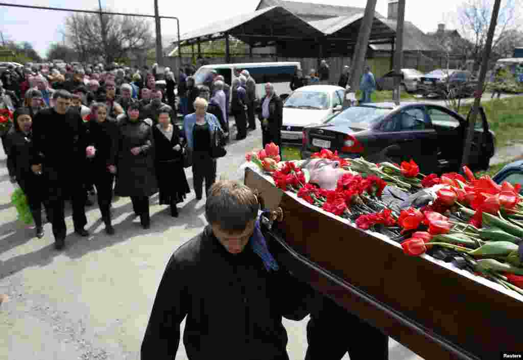 People carry the coffin of local politician Volodymyr Rybak, allegedly tortured and killed by pro-Russia separatists, during his funeral in the village of Horlivka, in eastern Ukraine, April 24, 2014.