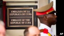 A member of the Cuban honor guard stands next to a new plaque at the front door of the newly reopened Cuban embassy in Washington, July 20, 2015. 