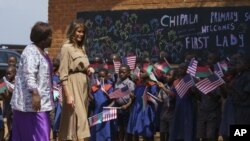 La primera dama Melania Trump es escoltada por la profesora Maureen Masi en su llagada a la Escuela Primaria Chipala, en Lilongüe. Noviembre 4, 2018.