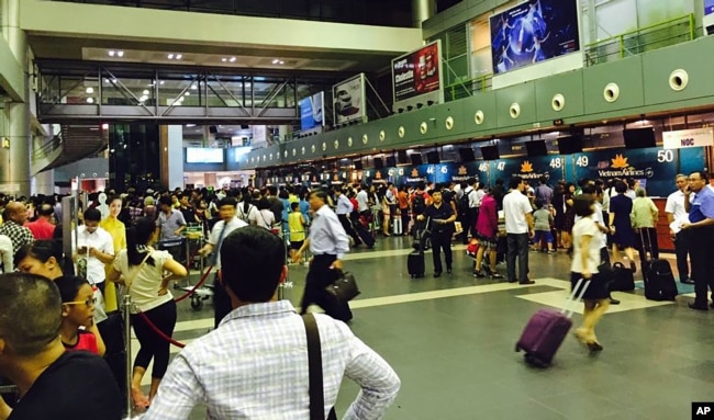 Passengers crowd check-in counters at Noi Bai Airport in Hanoi, Vietnam, July 29, 2016.