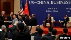 China's President Xi Jinping and U.S. President Donald Trump witness U.S. and Chinese business leaders signing trade deals at the Great Hall of the People in Beijing, China, Nov. 9, 2017. 