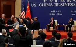 China's President Xi Jinping and U.S. President Donald Trump witness U.S. and Chinese business leaders signing trade deals at the Great Hall of the People in Beijing, China, Nov. 9, 2017.