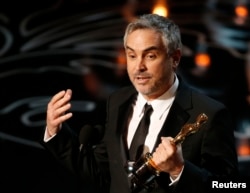FILE - Alfonso Cuaron accepts the Oscar for best director for "Gravity" at the 86th Academy Awards in Hollywood, California, March 2, 2014.
