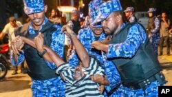  Maldivian police officers detain an opposition protester demanding the release of political prisoners during a protest in Male, Maldives, Feb. 2, 2018. Opponents of the Maldives government clashed with police on the streets of the capital Friday as they demanded the release of imprisoned politicians whose convictions were overturned by the Supreme Court. 