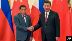 FILE - Philippine President Rodrigo Duterte, left, and Chinese President Xi Jinping pose for photographers on the sidelines of the Belt and Road Forum for International Cooperation at the Great Hall of the People in Beijing, May 15, 2017. 
