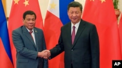 FILE - Philippine President Rodrigo Duterte, left, and Chinese President Xi Jinping pose for photographers on the sidelines of the Belt and Road Forum for International Cooperation at the Great Hall of the People in Beijing, May 15, 2017.