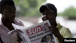 A man reads a newspaper with a headline related to the country's elections, at a news stand at Port Harcourt, in the Rivers state March 31, 2015. Nigeria's opposition contender Muhammadu Buhari held a sizeable lead as counting in the country's election re