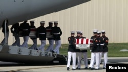 The remains of Americans killed in Benghazi this week are taken off a transport aircraft