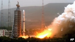 FILE - Photo released by China's Xinhua News Agency shows Olympic weather forecasting satellite, the Fengyun-3 (FY-3), launched on a Long March-4C carrier rocket from the Taiyuan Satellite Launch Center in northern Shanxi Province.