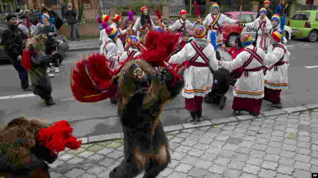 Des enfants de Dofteana, nord de la Roumanie, portant des fourrures d&#39;ours, effectuent des pas de danse lors d&#39;un rituel de la saison de vacances à Bucarest, Roumanie, mardi 23 décembre 2014