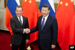1일 중국 베이징을 방문한 드미트리 메드베데프 러시아 총리(왼쪽)가 시진핑 중국 국가주석과 만나 악수하고 있다.