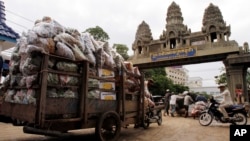 Cambodian workers transport their goods from Thailand at a Cambodia-Thai international border gate in Poipet, Cambodia, Wednesday, June 18, 2014 for their daily work near the border between Cambodia and Thailand. (AP Photo/Heng Sinith)