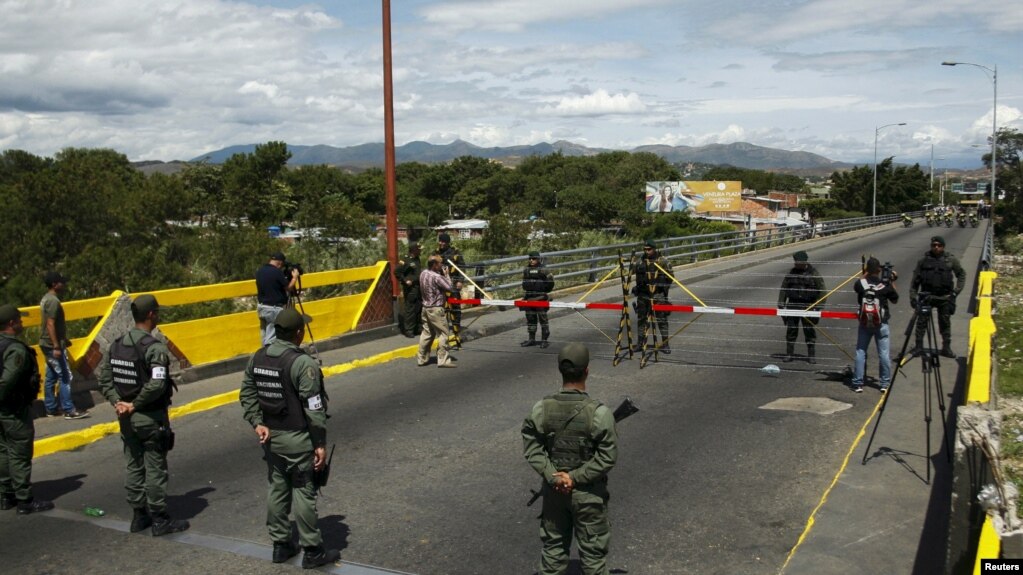 La Guardia Nacional de Venezuela (abajo) parada frente a soldados colombianos en el puente internacional Simón Bolívar, en Cúcuta, Colombia. Foto de archivo.