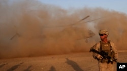 FILE - A U.S. Marine takes part in a training session for Afghan army commandos in Shorab military camp, Helmand province, Afghanistan, Aug. 27, 2017. 