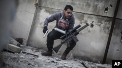 In this Friday, Jan. 18, 2013 photo, a sniper takes position on a roof during combat in the neighborhood of Saif Al-Dawlah in Aleppo, Syria. 