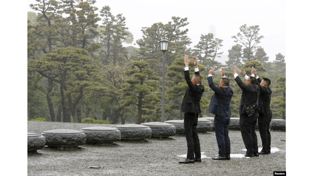 Orang-orang mengacungkan tangan sambil berteriak “Banzai” sambil menghadap ke arah Istana Kekaisaran pada hari turun takhta Kaisar Akihito di Tokyo, 30 April 2019. (Foto: Kyodo via Reuters)