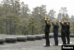 Orang-orang mengacungkan tangan sambil berteriak “Banzai” sambil menghadap ke arah Istana Kekaisaran pada hari turun takhta Kaisar Akihito di Tokyo, 30 April 2019. (Foto: Kyodo via Reuters)