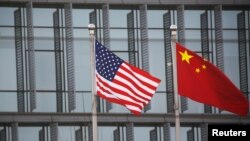 资料照片：美中国旗在一家美国公司驻北京的办公楼外飘扬。（2021年1月21日）
