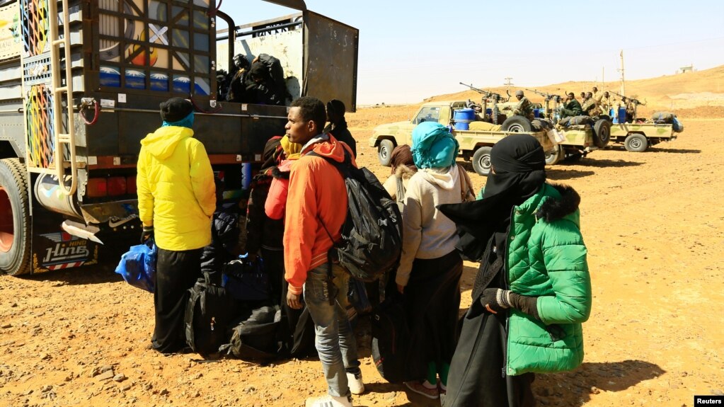 FILE - Illegal immigrants and traffickers who, according to the RSF, were caught while traveling in a remote desert area en route to Libya, gather to ride on a truck at Omdurman, Sudan, Jan. 8, 2017.