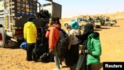 FILE - Illegal immigrants and traffickers who, according to the RSF, were caught while traveling in a remote desert area en route to Libya, gather to ride on a truck at Omdurman, Sudan, Jan. 8, 2017.