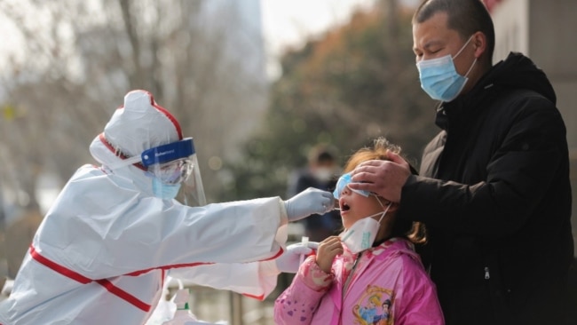 中国武汉的医务人员在给一个女孩进行核酸检测。（2020年3月5日）
