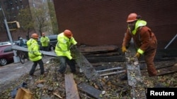 Workers clear debris outside Consolidated Edison power sub-station on 14th Street, New York, Oct. 30, 2012.