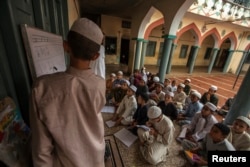 FILE - Pakistani religious students attend a lesson at Darul Uloom Haqqania, an Islamic seminary and alma mater of several Taliban leaders, in Akora Khattak, Khyber Pakhtunkhwa province, Sept. 14, 2013. Many Pakistani religious schools, so-called madrassas, are widely seen as breeding grounds of violent extremism.