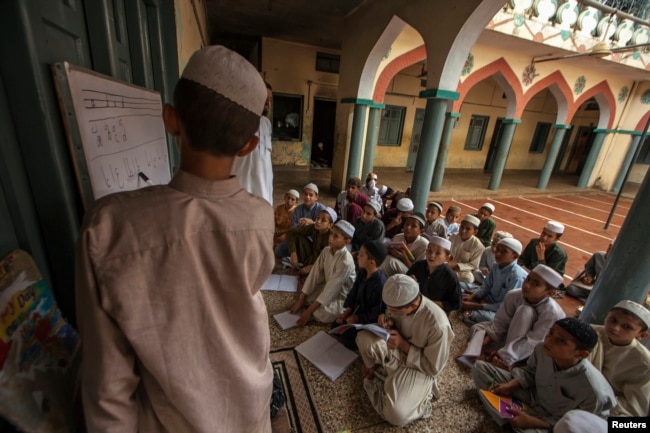 FILE - Pakistani religious students attend a lesson at Darul Uloom Haqqania, an Islamic seminary and alma mater of several Taliban leaders, in Akora Khattak, Khyber Pakhtunkhwa province, Sept. 14, 2013. Many Pakistani religious schools, so-called madrassas, are widely seen as breeding grounds of violent extremism.