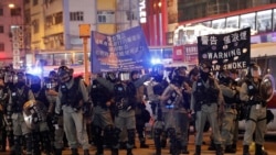 香港防暴警察在圣诞日向示威者展开警示将要采取镇压行动的旗子。（2019年12月25日）