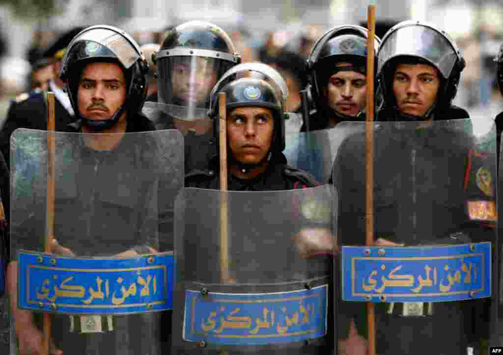 January 26: Riot police keep watch as they hold shields during clashes with protesters in Cairo. Thousands of Egyptians defied a ban on protests by returning to Egypt's streets on Wednesday and calling for President Hosni Mubarak to leave office, and some