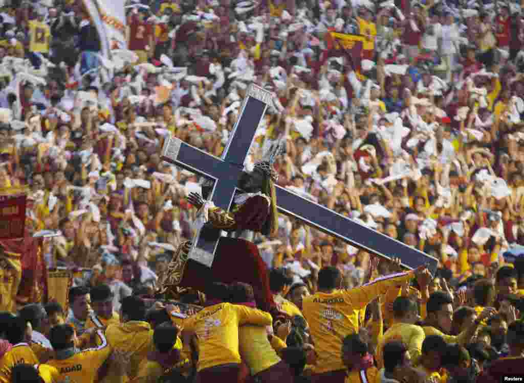 Devotees carry the Black Nazarene at the start of an annual procession in Manila. More than a million barefoot devotees joined the parade ahead of Pope Francis&#39; visit to the Philippines next week. The Black Nazarene, a life-size wooden statue of Jesus Christ carved in Mexico and brought to the Philippines in the 17th century, is believed to have healing powers in the predominantly Roman Catholic country.